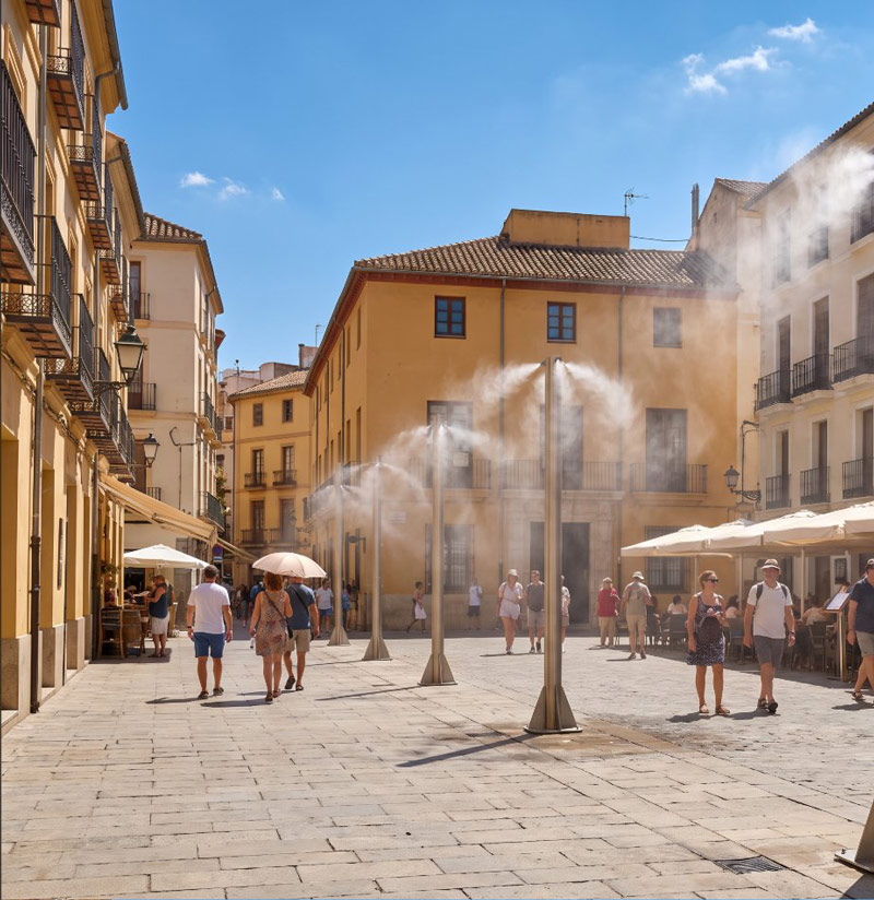 Historic European square on a hot day with discreet misting poles cooling café terraces